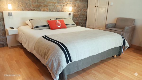 Lit double avec son mur en pierres